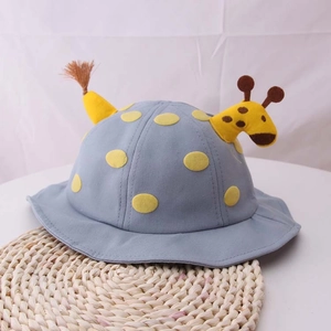 Simpatico cappello da sole blu per neonati con design a giraffa e pois su tappeto di paglia