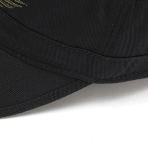 Macro du tissu en sergé de coton et de la broderie dorée sur la casquette noire