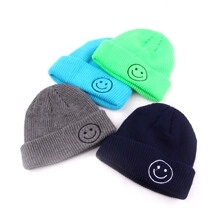 Detailed view of colorful knit beanies featuring ribbed texture and smiley face embroidery