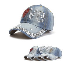Vista dettagliata del berretto in denim con motivi LOVE in strass e visiera decorata con cristalli