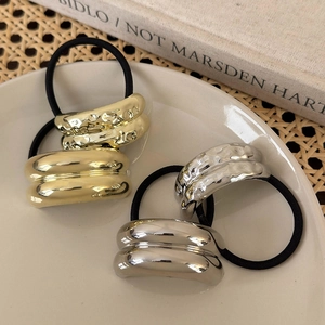 Set of minimalist gold and silver metallic elastic hair ties with textured wave pattern