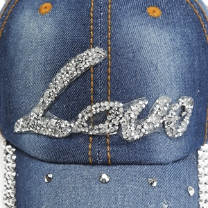Détail d'une casquette en jean bleu avec lettrage Love en strass argentés scintillants