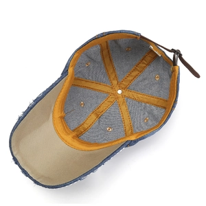 Détail de l'intérieur d'une casquette en denim avec sangle en cuir et bordure jaune