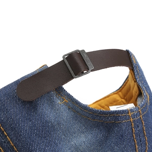 Détail de la sangle en cuir et boucle métallique sur casquette en jean bleu