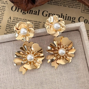 French vintage gold metal flower earrings with white pearls on a jewelry box