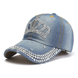 Dettaglio cappello baseball in denim blu con corona di strass argento e bordo decorato