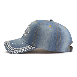 Vista dettagliata del cappellino da baseball in denim blu con lettera B in strass