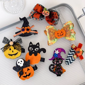 Halloween hair clips set featuring pumpkin, ghost and bat motifs on a silver tray