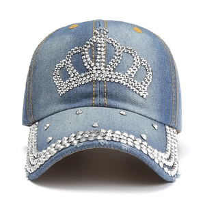 Dettaglio della corona di strass e borchie d'argento sul cappello da baseball denim