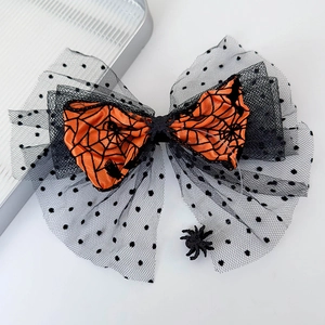Detail of Halloween hair clip with orange spider web satin and black polka dot mesh bow