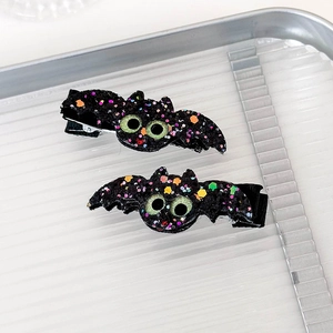 Close-up of Halloween bat hair clips with black glitter and colorful sequins for cosplay