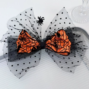 Detail of Halloween hair clip with orange spider web bow and black mesh polka dots