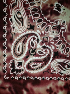 Close-up of vintage red paisley pattern on cotton bandana showing fabric texture and detail