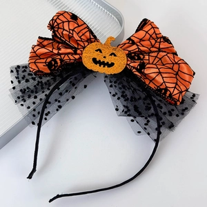 Detail of Halloween headband featuring orange pumpkin ribbon with black spider web pattern