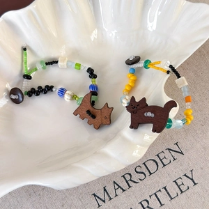 Vue détaillée de bracelets en perles colorées faits main avec breloques en bois de chien