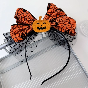 Detail of Halloween headband featuring orange sequin pumpkin and spider web lace bow