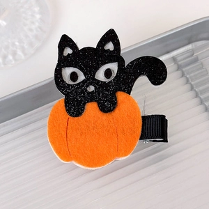 Detail of Halloween hair clip with glitter cat and orange felt pumpkin on a tray