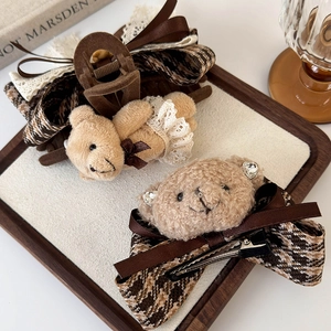 Plush teddy bear hair claw clips with lace and houndstooth bow in a rustic tray