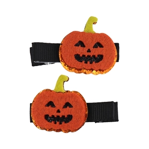 Detail of two handmade felt pumpkin hair clips with orange glitter accents for Halloween costumes