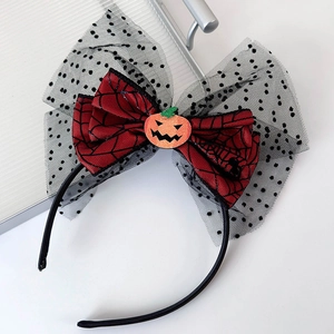 Detail view of Halloween headband with black mesh bow, spider web pattern and pumpkin decor