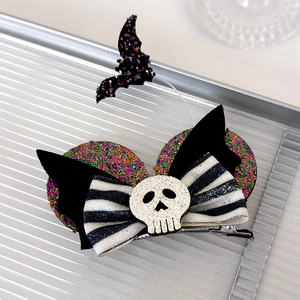 Detail of Halloween hair clip with bat wings, glitter skull, and striped bow tie decor