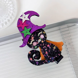 Detail of glittery black cat hair clip with purple witch hat for Halloween celebration