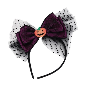 Close-up of Halloween headband with purple spider web bow and orange pumpkin face detail