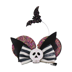 Detail view of Halloween bow hair clip featuring sequins, skull, and bat wing elements