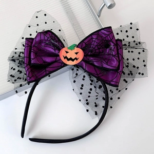 Detail of Halloween headband with purple spider web bow and orange pumpkin charm