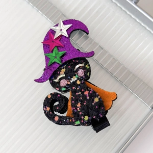 Close-up of Halloween cat wizard hair clip with glitter sequins and felt cape details