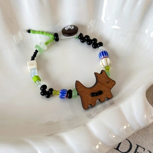 Gros plan sur bracelet perlé fait main avec breloque chien en bois dans un coquillage