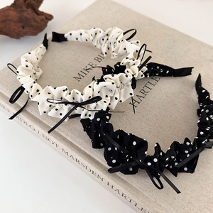 Detailed view of ruffled polka dot headbands with black silk ribbons and bow accents