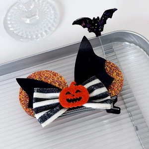 Macro shot of Halloween hair clip with black sequin bat, pumpkin patch and striped bow