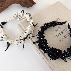 Polka dot bow headband with pleated fabric detail in classic black and white style
