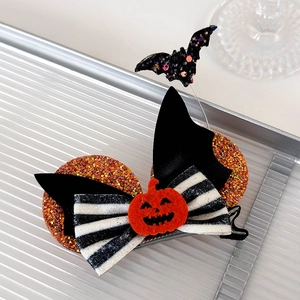 Detail of Halloween hair clip with black glitter bat, orange pumpkin, and striped bow