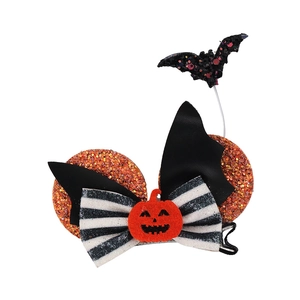 Close-up of Halloween sequined hair clip with orange pumpkin, bat, and striped bow