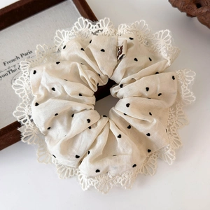Dettaglio dell'elastico crema a pois neri con bordo in pizzo e etichetta orso