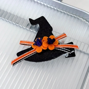 Detail of Halloween felt wizard hat hair clip with orange flowers and striped ribbon