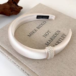 Detail of luxury padded champagne headband with rows of faux pearls on fabric