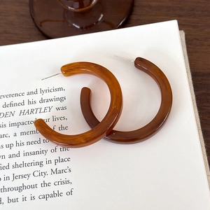 Dettaglio delle orecchie in resina a forma di C con tartaruga ambra su un libro