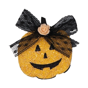 Detail of yellow sequined Halloween pumpkin hair clip with black lace bow and resin rose