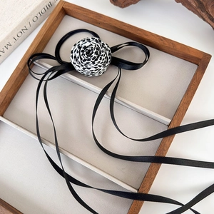 Dettaglio di un elegante elastico per capelli con fiore leopardato e lunghi nastri di seta