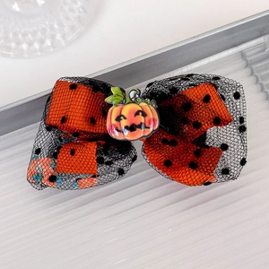 Detail of Halloween bow hair clip featuring a resin pumpkin and black mesh lace