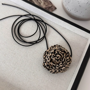 Detailed close-up of leopard print fabric rose choker with black adjustable cord string