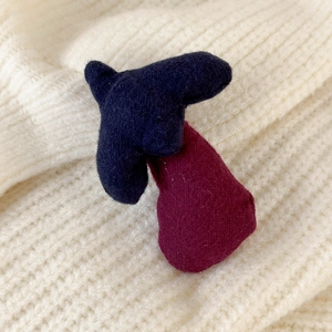 Dettaglio macro di fermagli per capelli in velluto blu e bordeaux su maglione