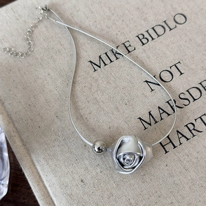 Detailed view of leather rose necklace with silver-tone beads and adjustable lobster clasp