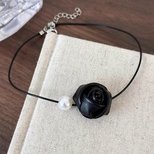 Close-up of leather rose and pearl choker necklace with an adjustable metal chain extender