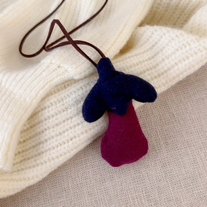 Close-up of handmade forest style eggplant pendant necklace for girls with soft velvet texture