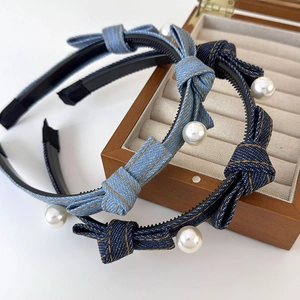 Detailed view of denim bow headbands featuring white pearls and non-slip inner grip teeth