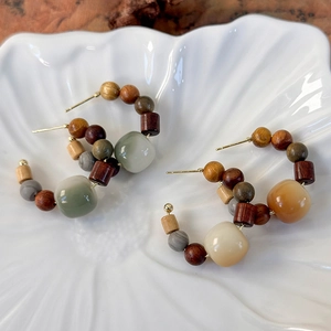 Ethnic wood bead hoop earrings in vintage sandalwood style displayed on a shell plate